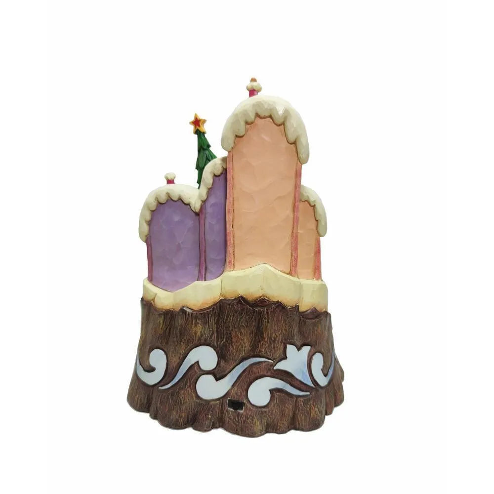 Rear view of Grinch Who-ville scene figurine showing snow-capped pastel pink and purple buildings on a folk art scrollwork log base