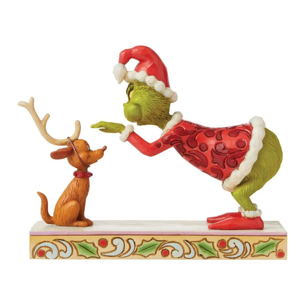 Rear angle of Grinch and Max figurine, Grinch in red scrollwork Santa suit facing Max in reindeer antlers, holly patterned base 