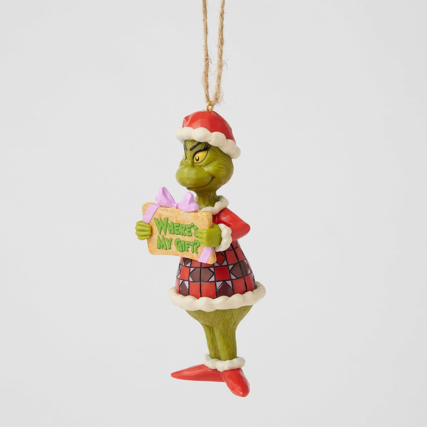 Side view of Grinch hanging ornament in red Santa hat and patterned coat, holding "Where's My Gift?" sign with purple bow 