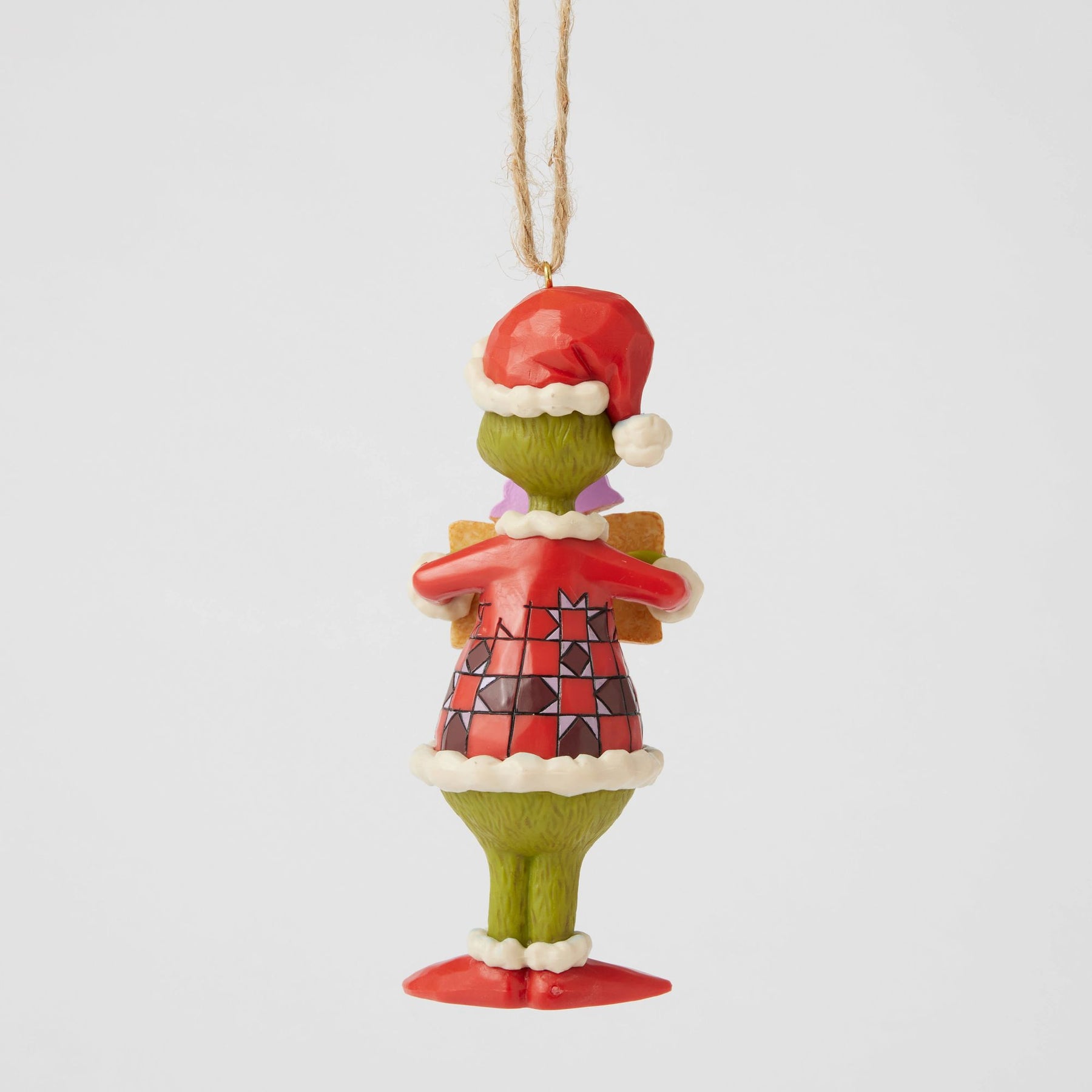 Rear view of Grinch Christmas ornament showing red geometric patterned coat detail, Santa hat, and jute cord hanger