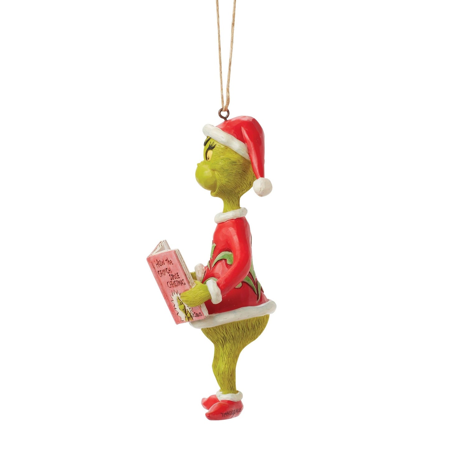 Side profile of Grinch hanging ornament in Santa hat, holding How the Grinch Stole Christmas book, twine hanger
