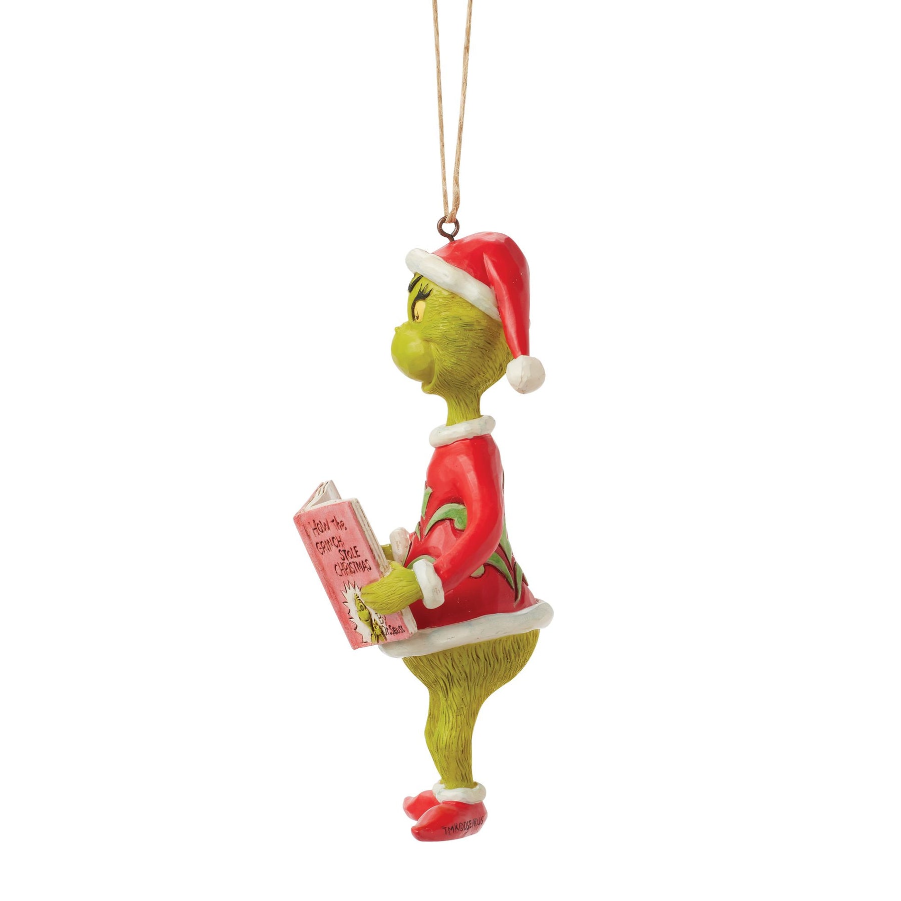 Side profile of Grinch hanging ornament in Santa hat, holding How the Grinch Stole Christmas book, twine hanger