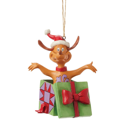 Max the dog hanging ornament in Santa hat, popping out of a green gift box with red bow and star-patterned panel, twine hanger