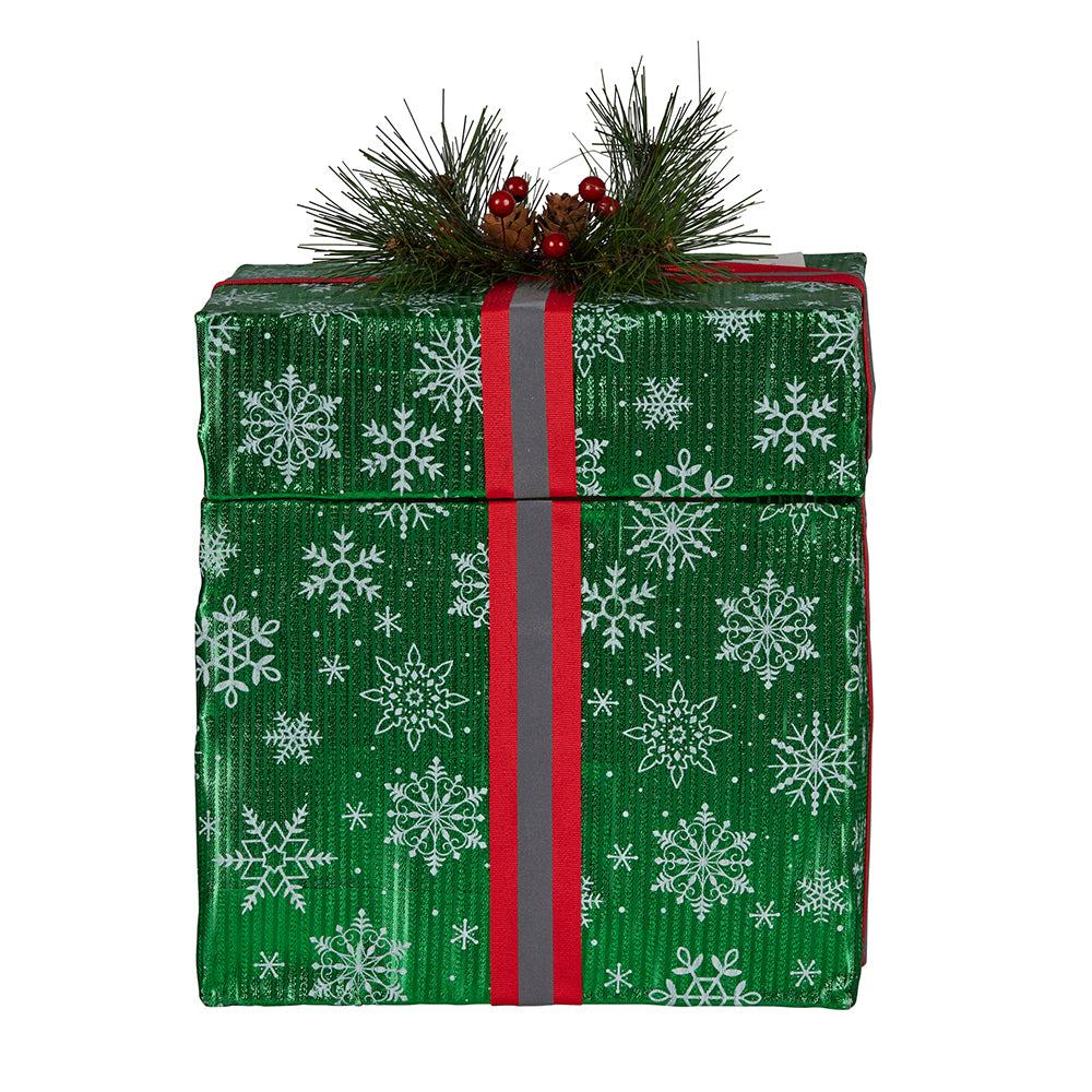 Green snowflake gift box decoration with red ribbon and pine cone berry detail, unlit