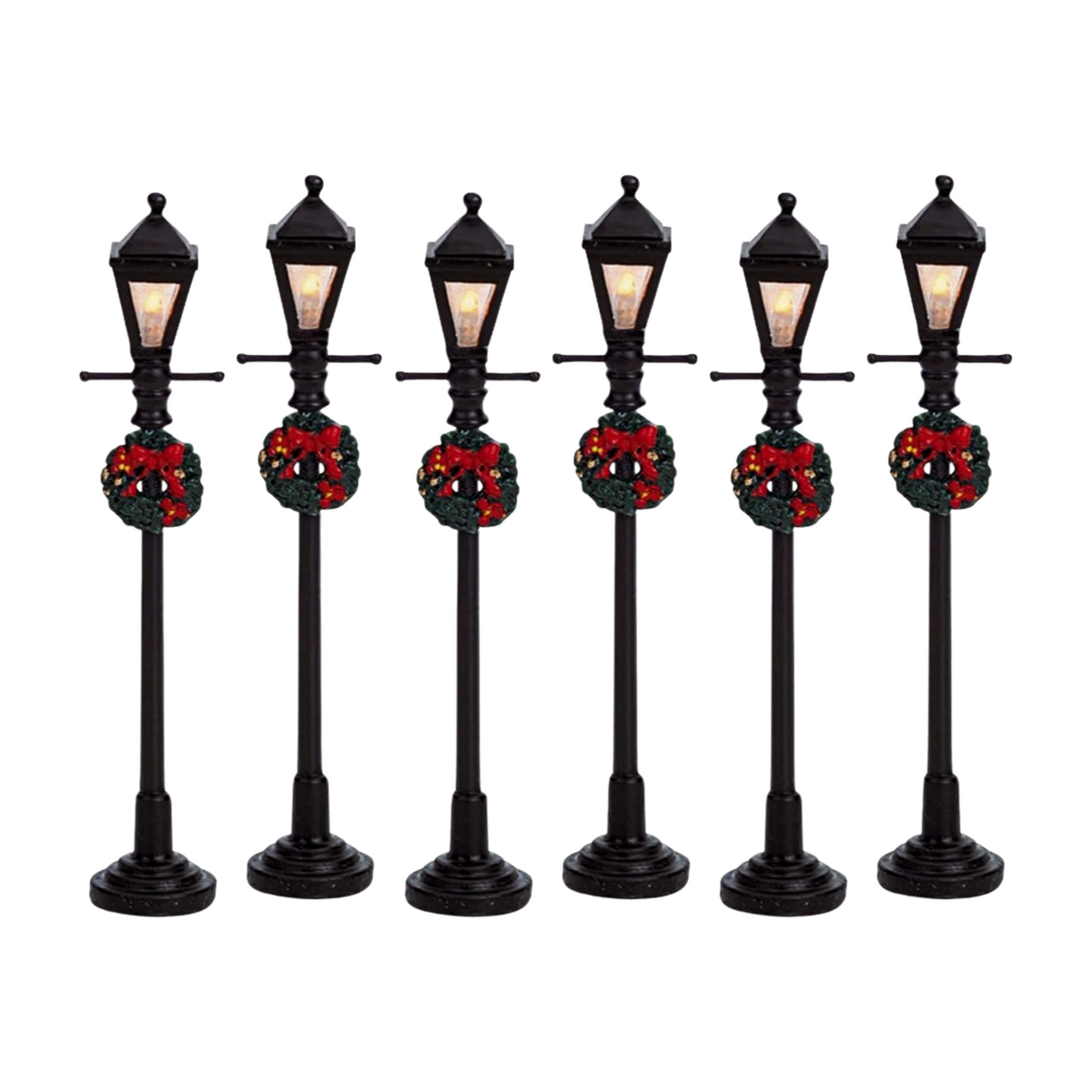 Set of six Christmas village gas lamp post figurines in black with warm lit lanterns and red-bow wreaths, on round bases