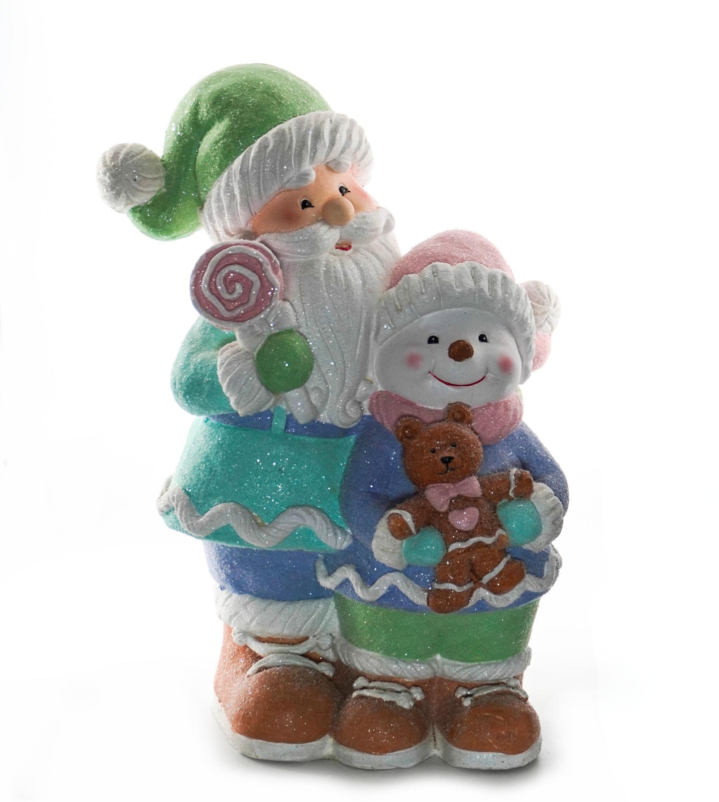 Santa figurine in a green hat holding a candy swirl standing beside a snowman with a teddy bear