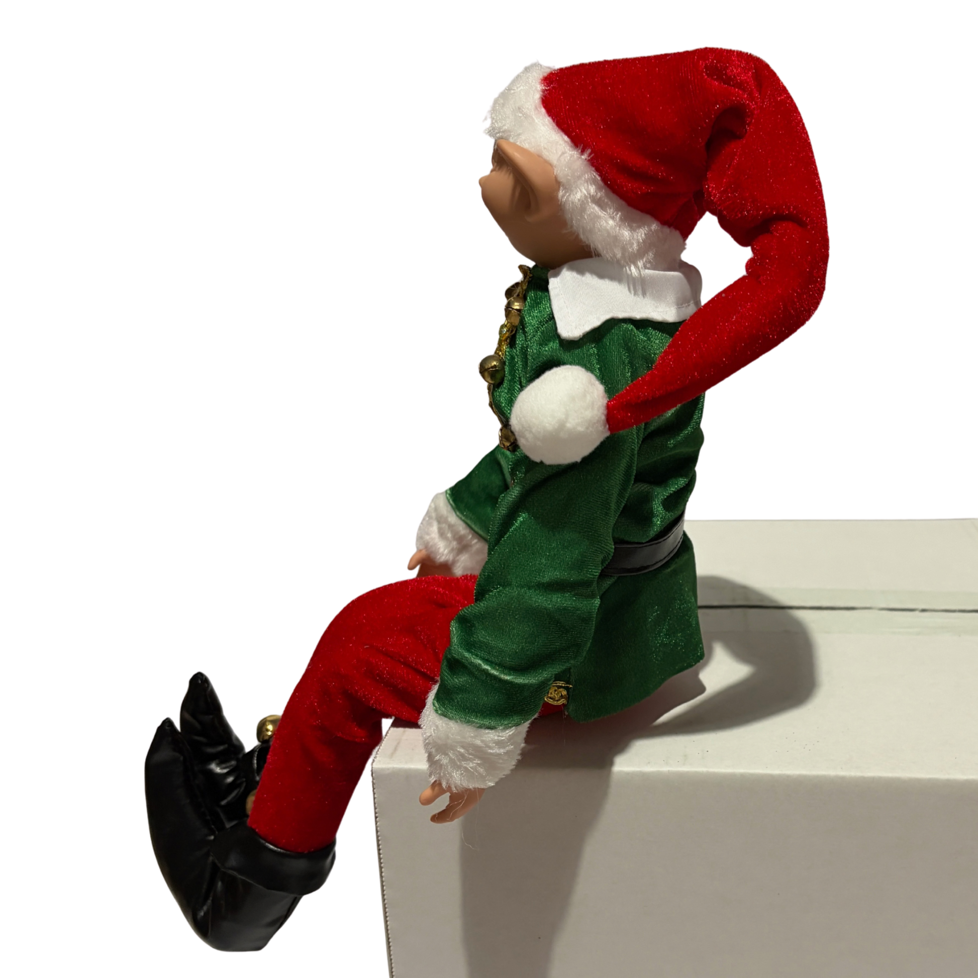 Sitting Christmas elf in green jacket and red trousers with a red hat and black boots