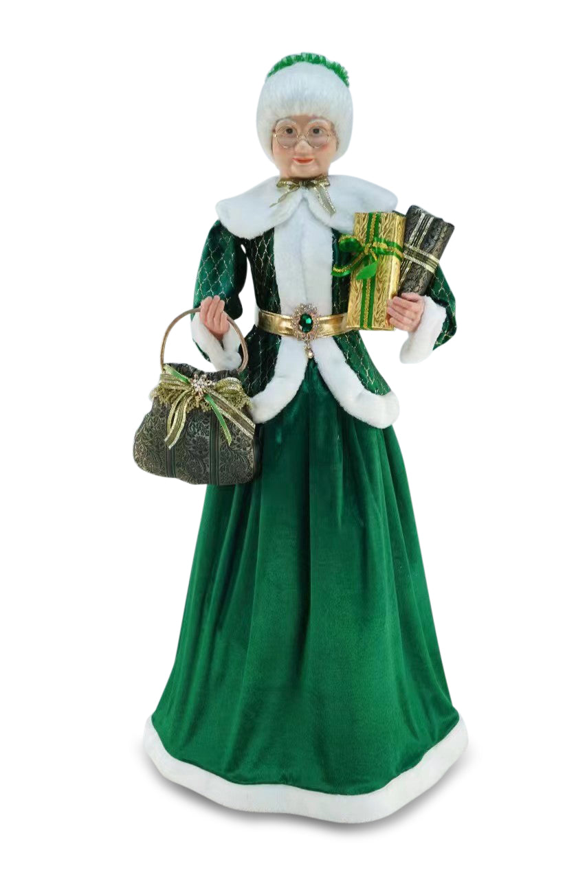 Green velvet Mrs Claus figure holding gifts and handbag