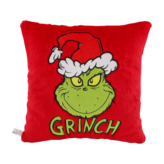 Red square cushion with an embroidered image of the Grinch smiling in a Santa hat and the word “Grinch” below