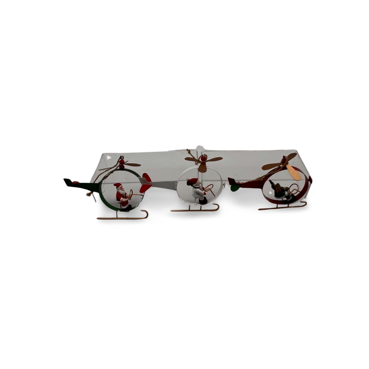Three metal Christmas helicopter ornaments in red, green, and white, each with a festive character—Santa, snowman, or reindeer—piloting with spinning propeller blades and gold landing skis.
