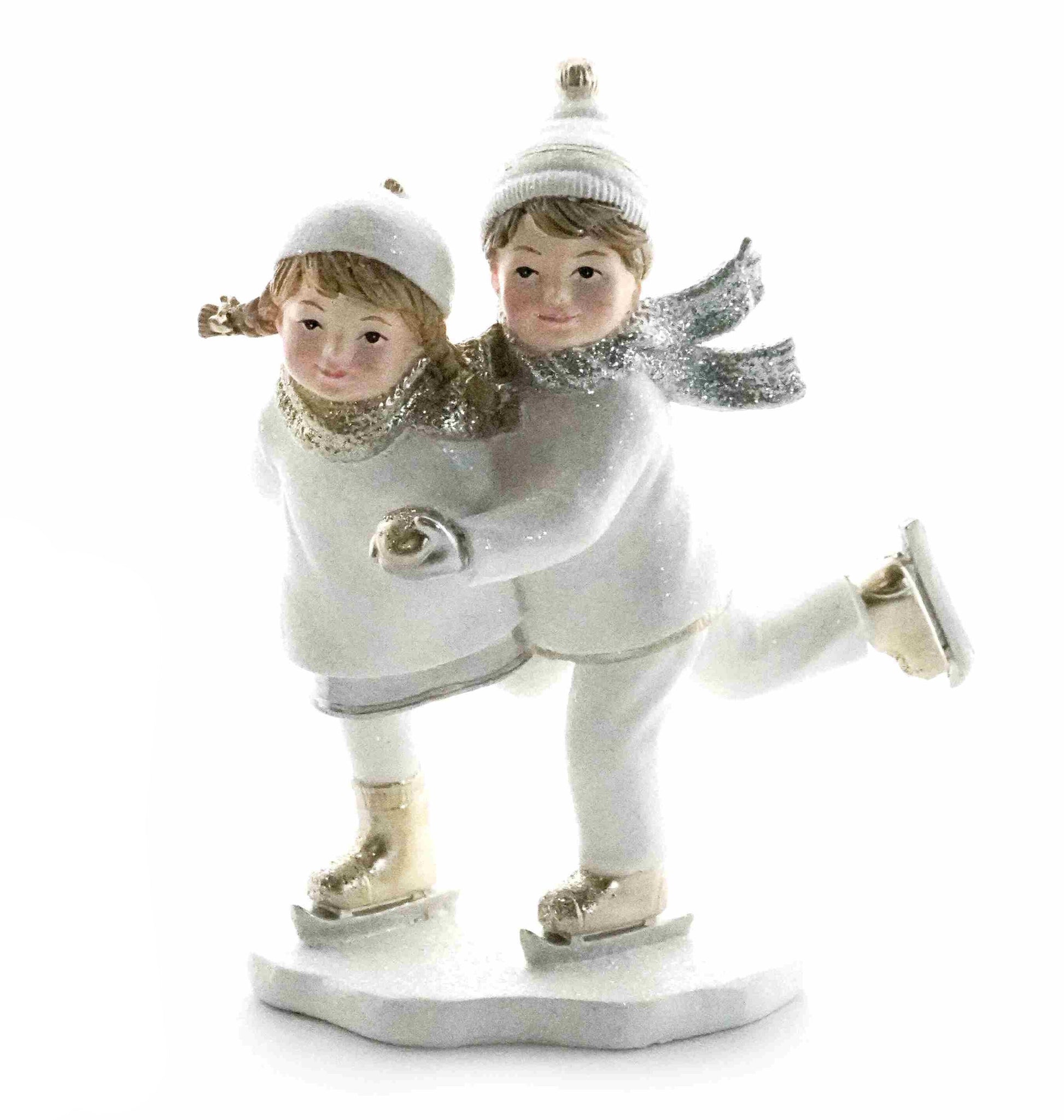 Figurine of two children ice skating together in white winter outfits with silver accents