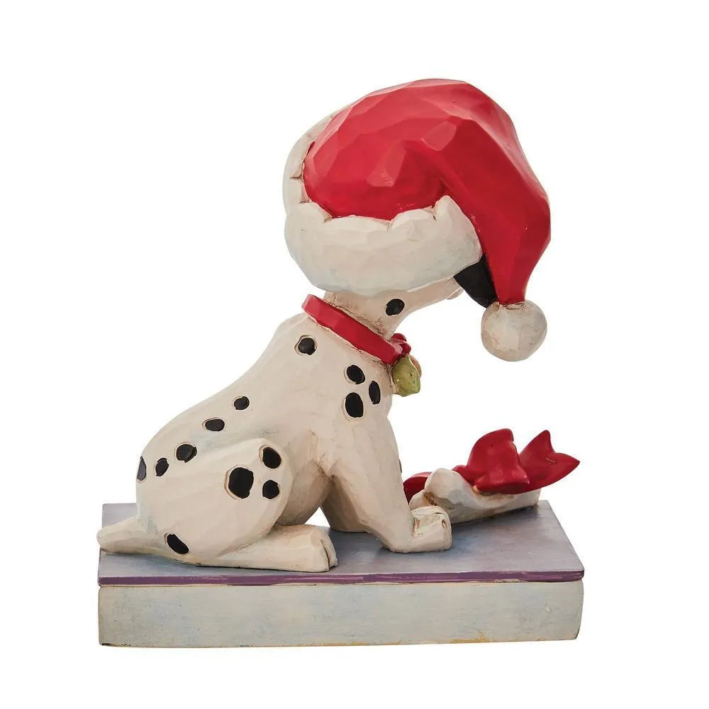 Rear view of a Dalmatian puppy figurine in a Santa hat with red collar, bone gift with red bow, holly and spot-patterned base