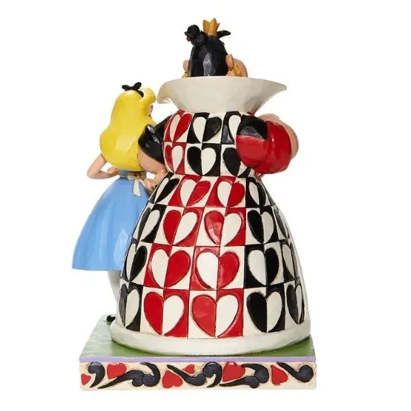 Rear view of Alice and Queen of Hearts figurine showing bold red and black heart pattern across the Queen's full skirt