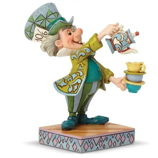 Mad Hatter figurine front view, pouring teapot into stacked cups, green top hat with 10/6 ticket, scrollwork coat, diamond pattern base