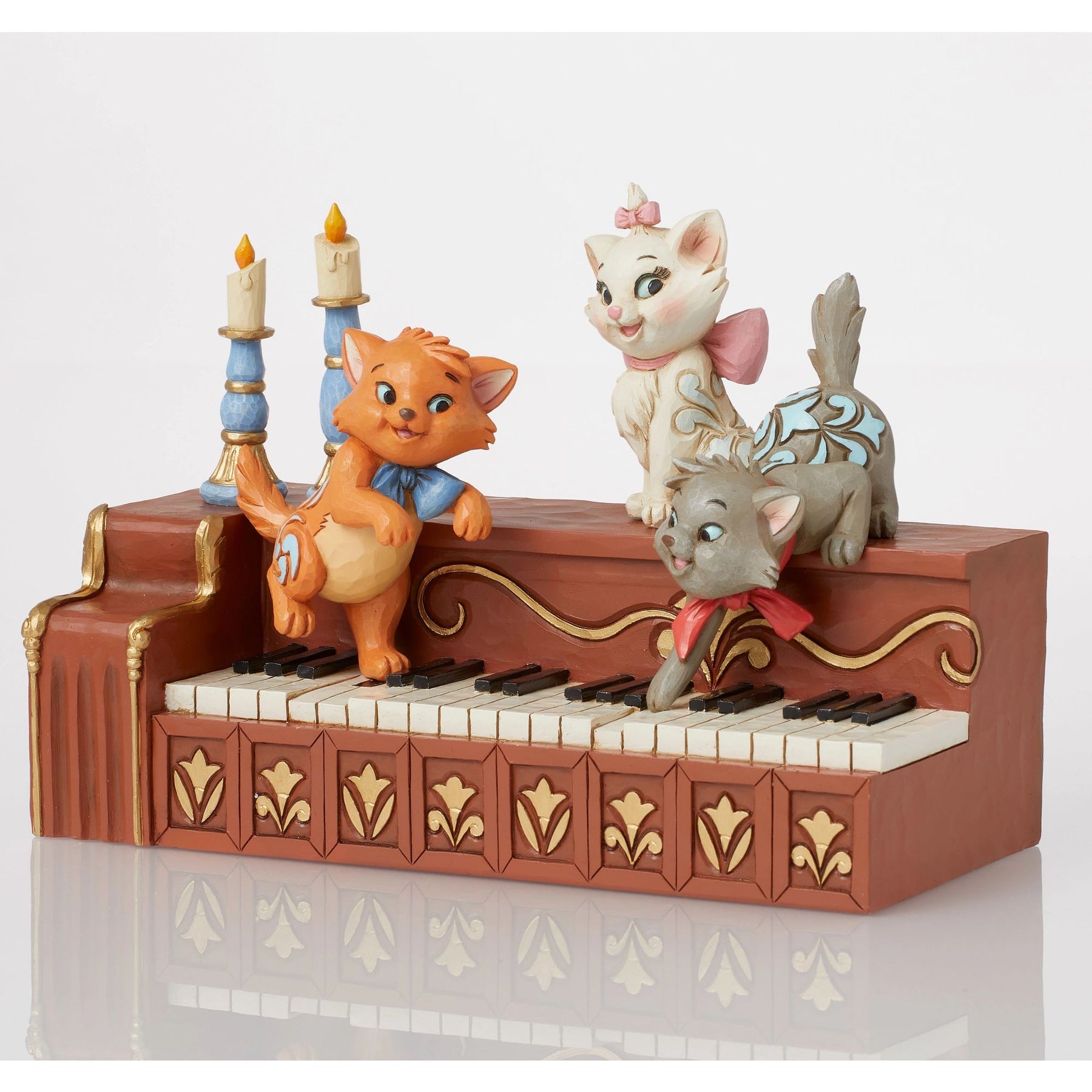 Front view of Marie, Toulouse and Berlioz figurine on piano with blue candlesticks and gold tulip painted front