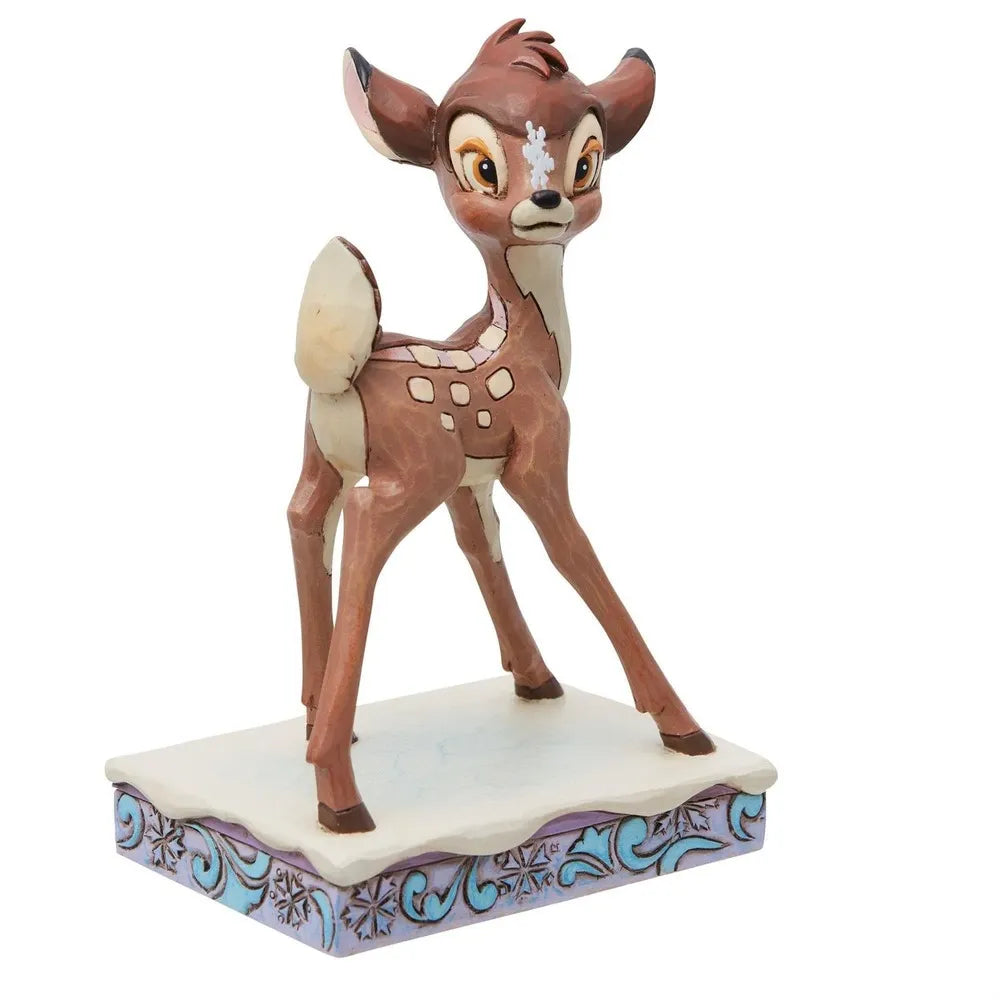 Close front view of a Bambi fawn figurine with wide eyes and a snowflake accent, on a blue and purple scrollwork base