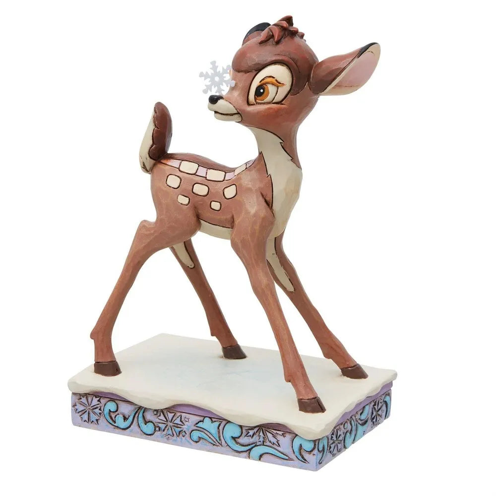 Angled front view of a Bambi fawn figurine with a painted snowflake on his nose, on a snowflake-detailed base