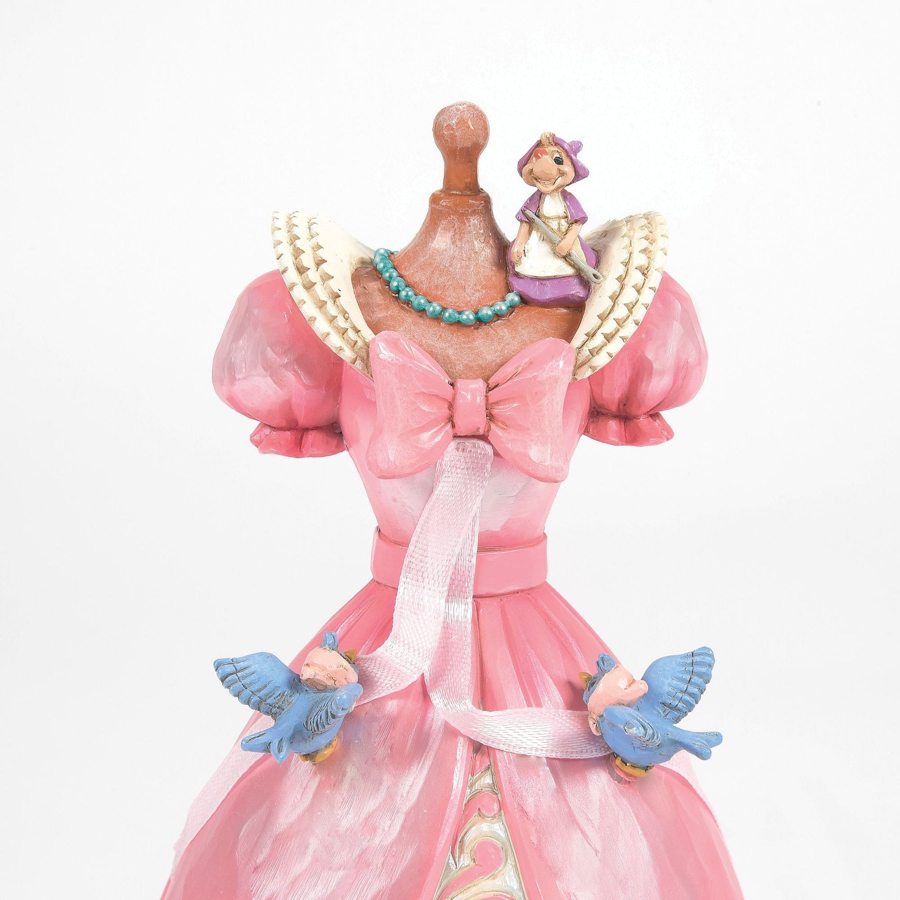 Close-up of Cinderella dress figurine top, showing mouse with needle, teal bead necklace, bluebirds holding ribbon