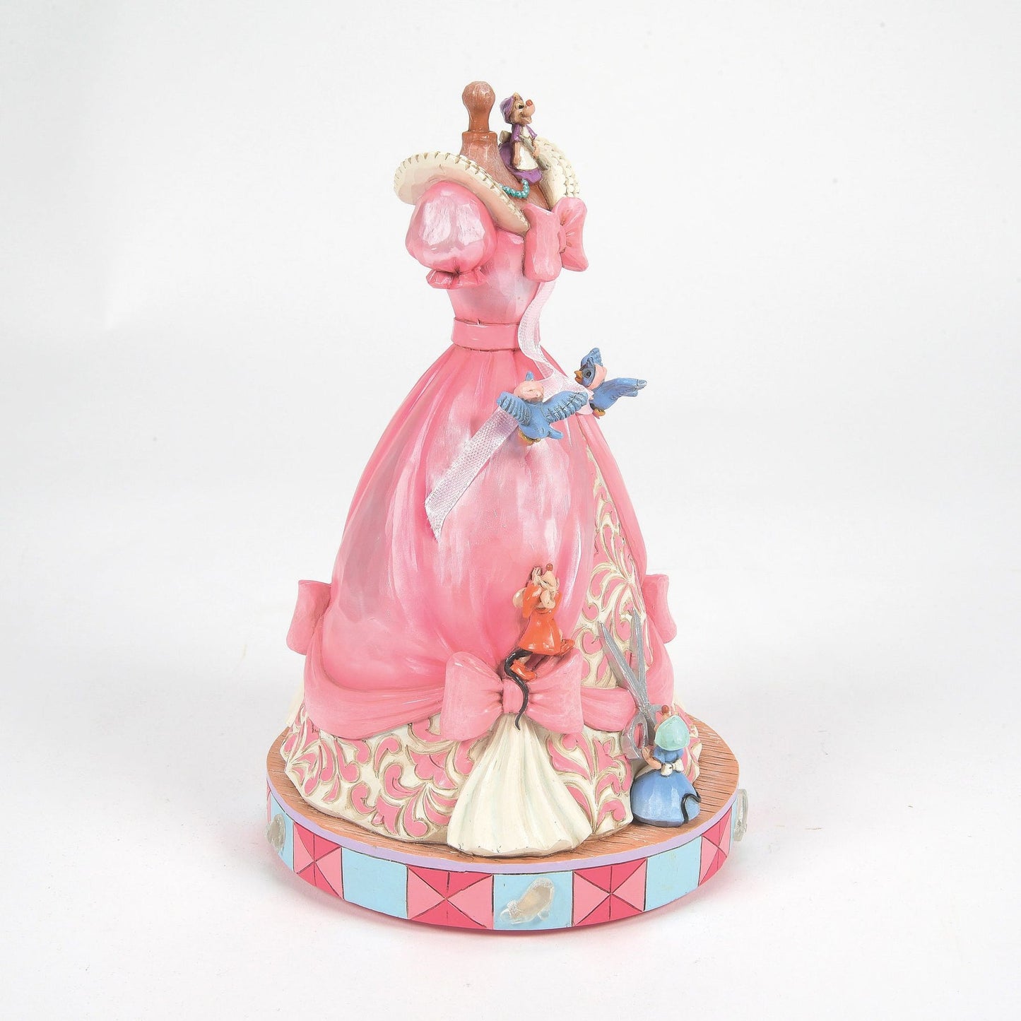 Left side view of Cinderella pink dress on mannequin figurine with mice, bluebirds, scrollwork skirt, pink and blue base
