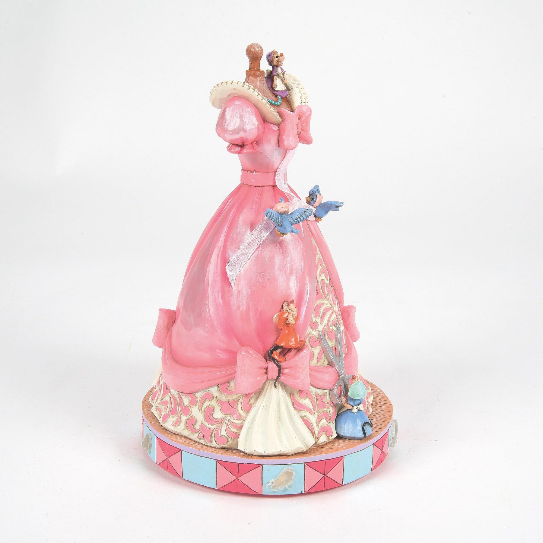 Left side view of Cinderella pink dress on mannequin figurine with mice, bluebirds, scrollwork skirt, pink and blue base