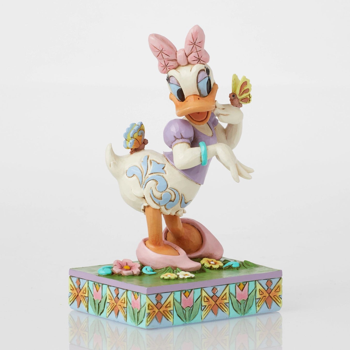 Front view of Daisy Duck spring figurine with two butterflies, pink bow, scrollwork body detail, floral tulip base