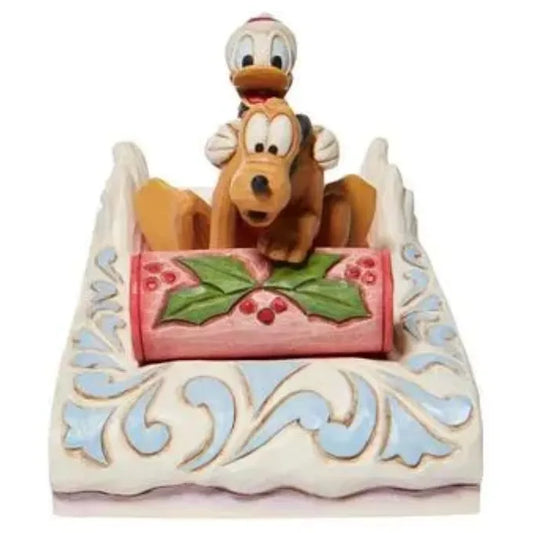 Donald Duck and Pluto Christmas figurine riding together in a white folk art sleigh with holly detail on the front panel