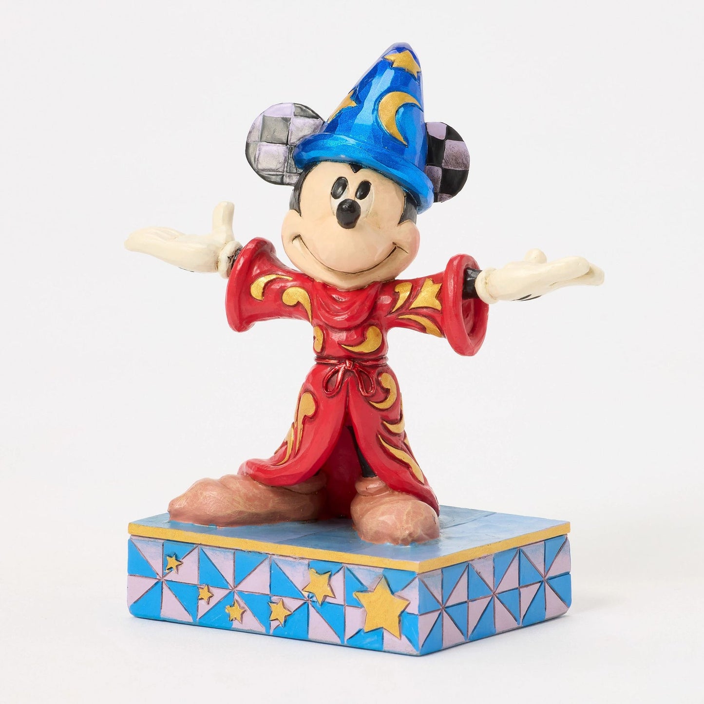 Front view of Sorcerer Mickey Mouse figurine, red robe with gold scrollwork, blue star hat, arms wide, star base