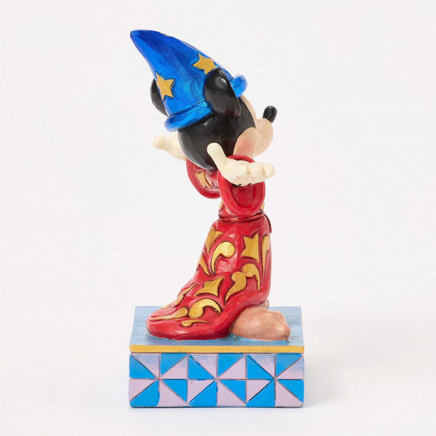 Side view of Sorcerer Mickey Mouse figurine in red and gold robe, blue star hat with moon detail, star base