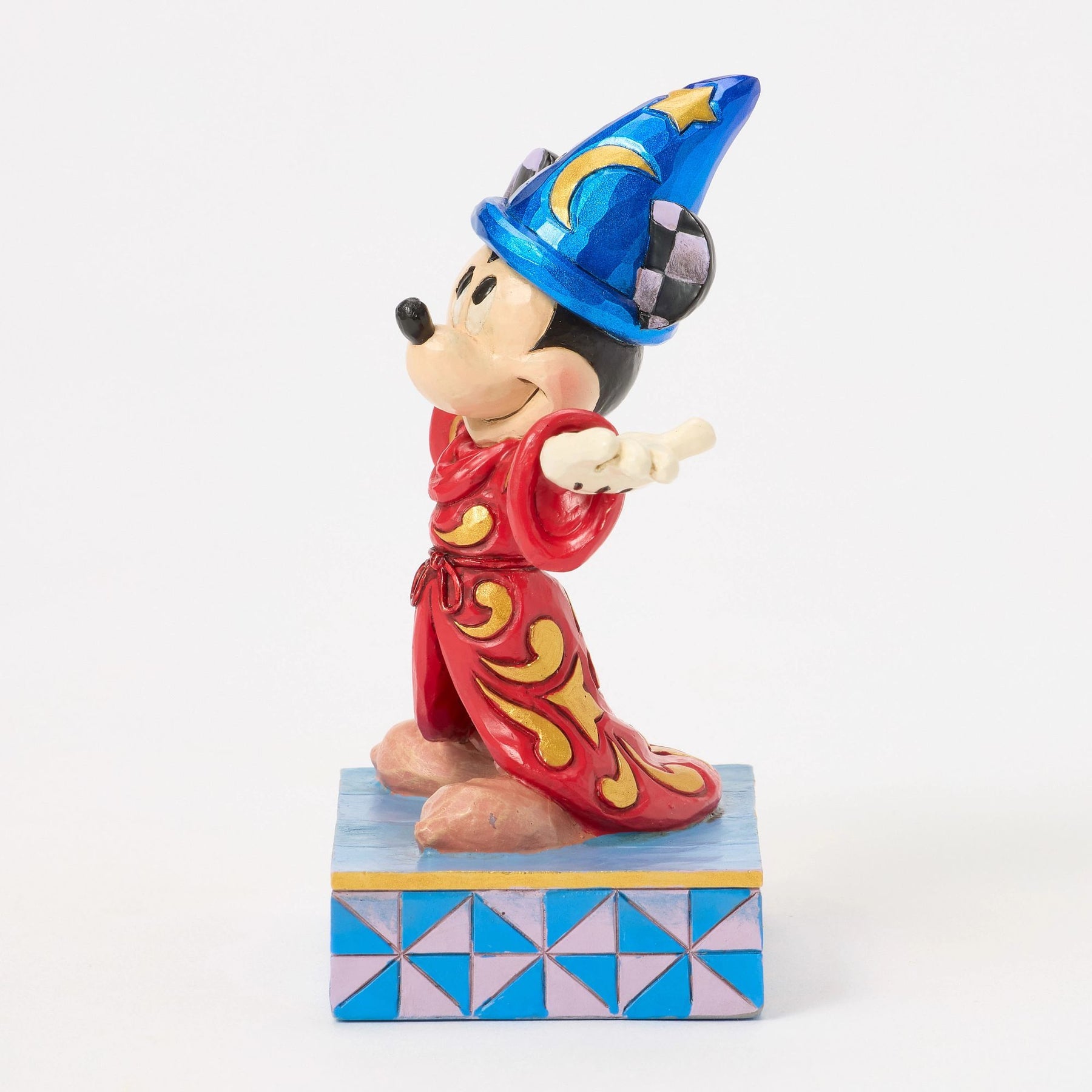 Opposite side view of Sorcerer Mickey Mouse figurine, red and gold scrollwork robe, blue star hat, star base