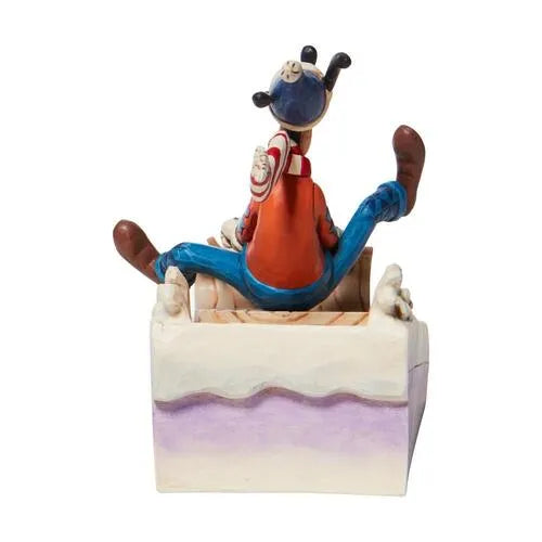 Rear view of Goofy Christmas sledding figurine, Goofy in blue and red outfit seated in a folk art sled, scrollwork base