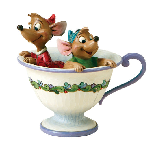 Jaq and Gus Cinderella mouse figurines peering over the rim of a cream teacup with green and purple scrollwork band