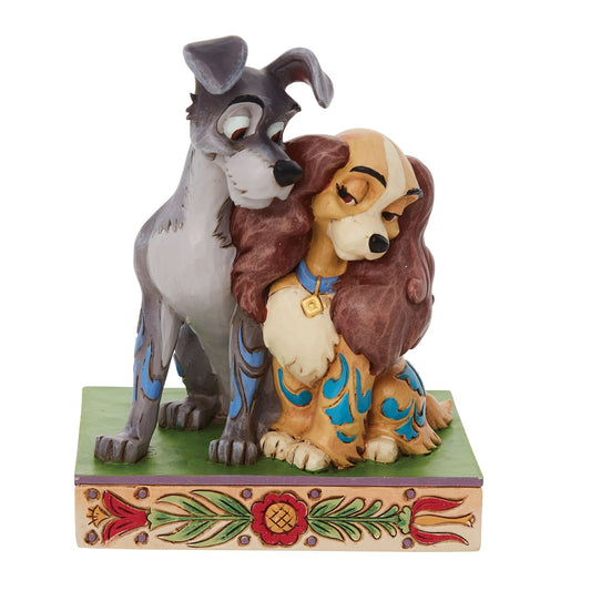 Lady and the Tramp figurine, Tramp standing close behind Lady, both with scroll-painted coats on a floral decorated base