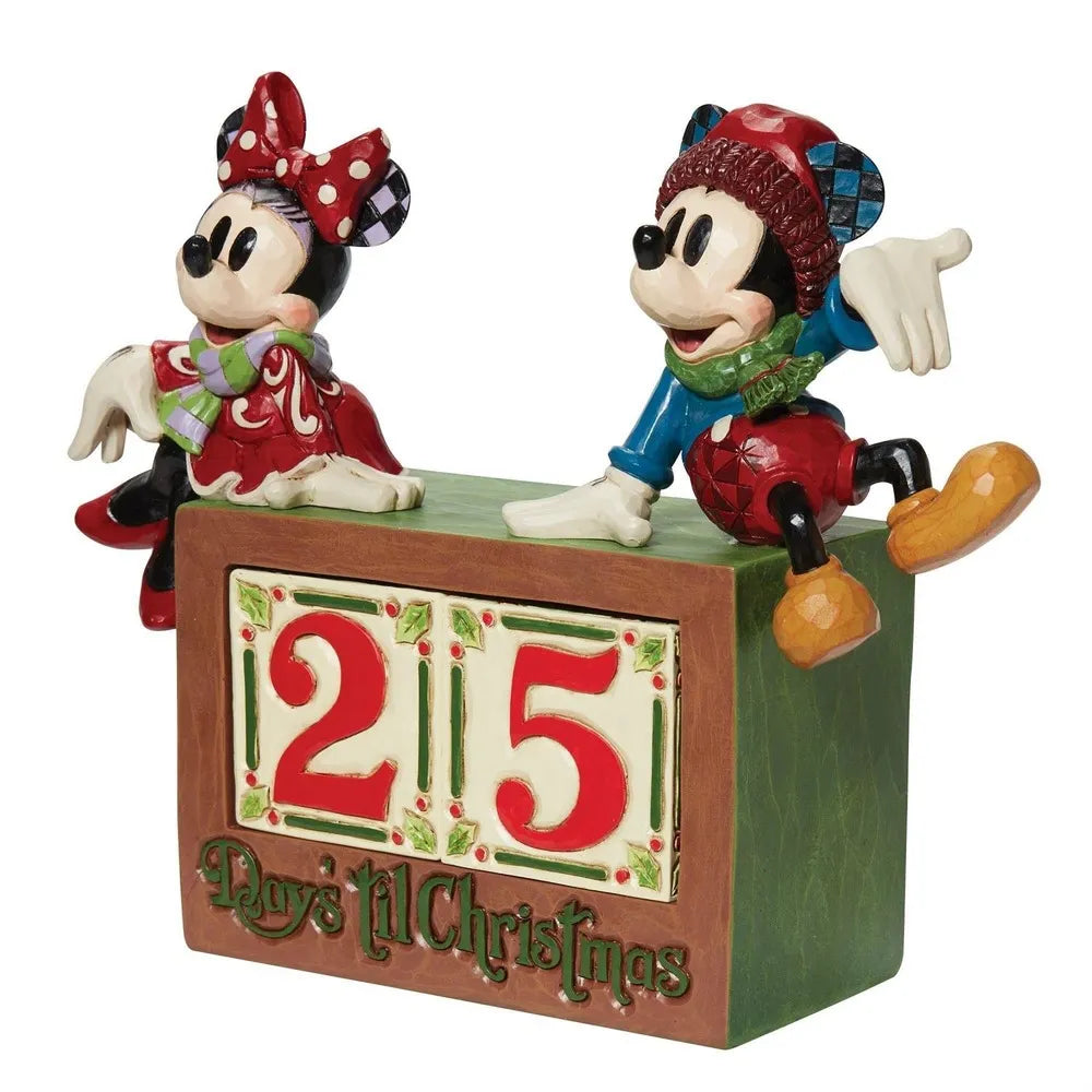 Angled side view of Mickey and Minnie Mouse Christmas figurines seated on a "Days 'til Christmas" numbered countdown block. 