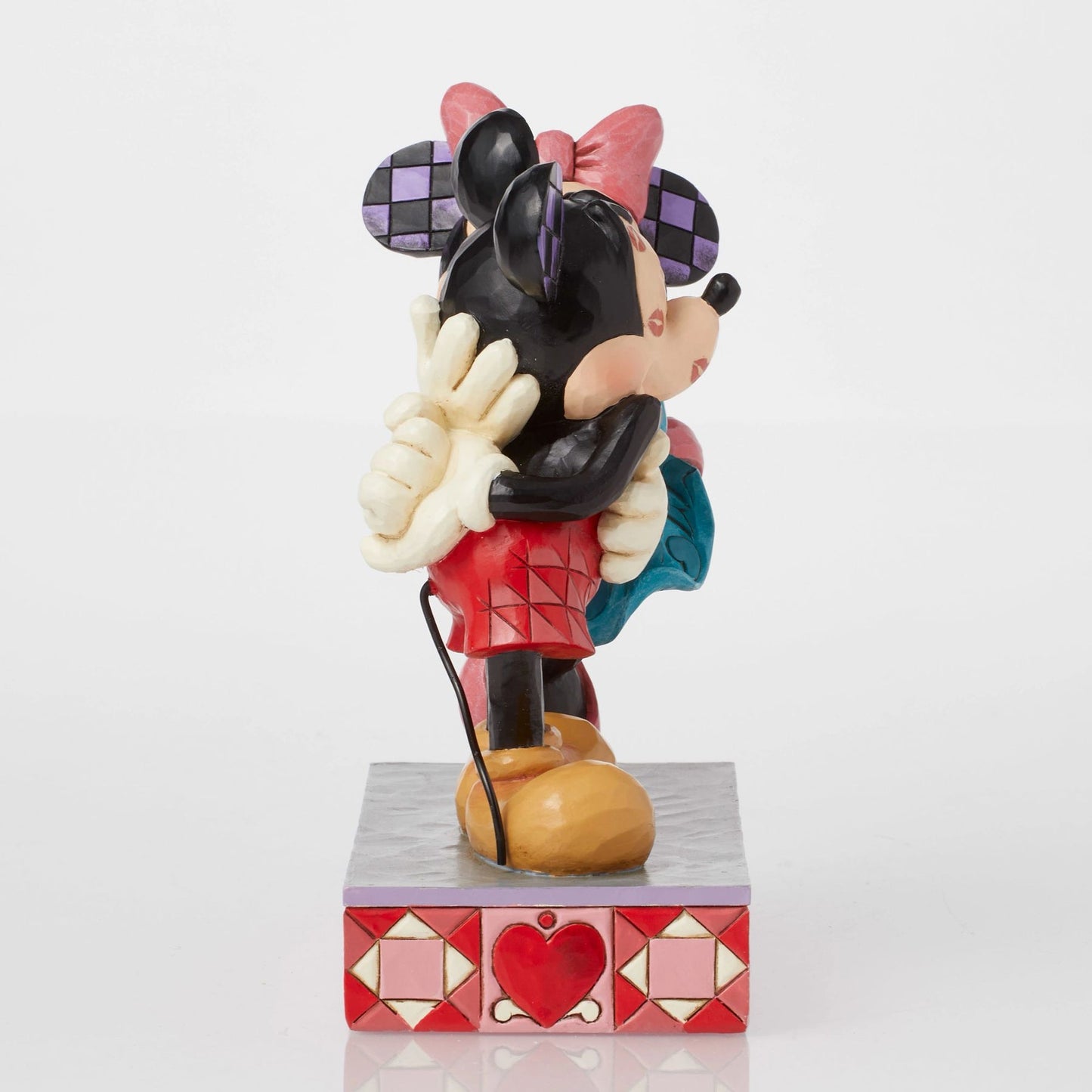 Side view of Minnie Mouse kissing Mickey Mouse figurine, teal dress detail, heart-patterned painted base
