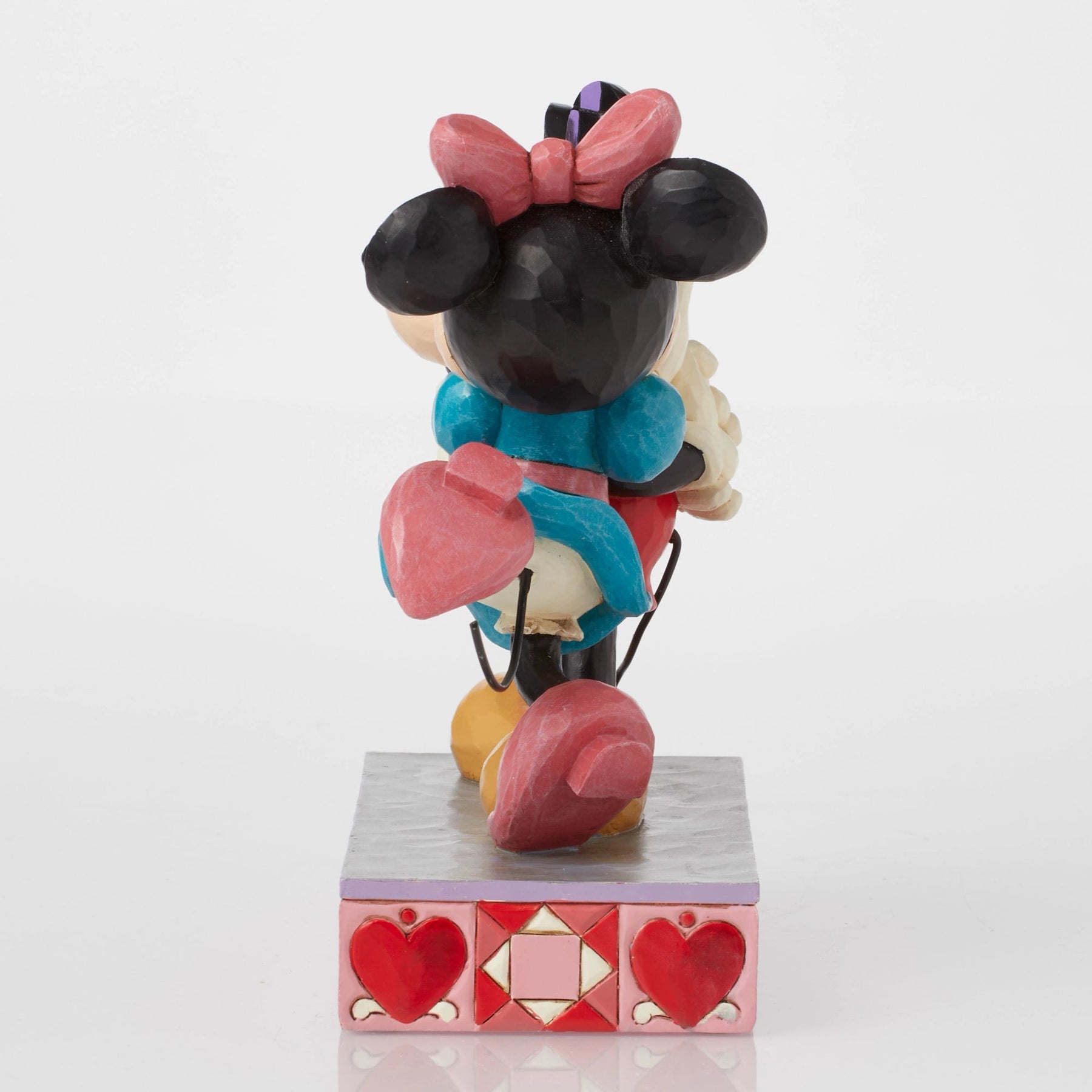 Mickey and Minnie Mouse figurine hugging with kiss marks on Mickey's face, checkered ear detail, heart base