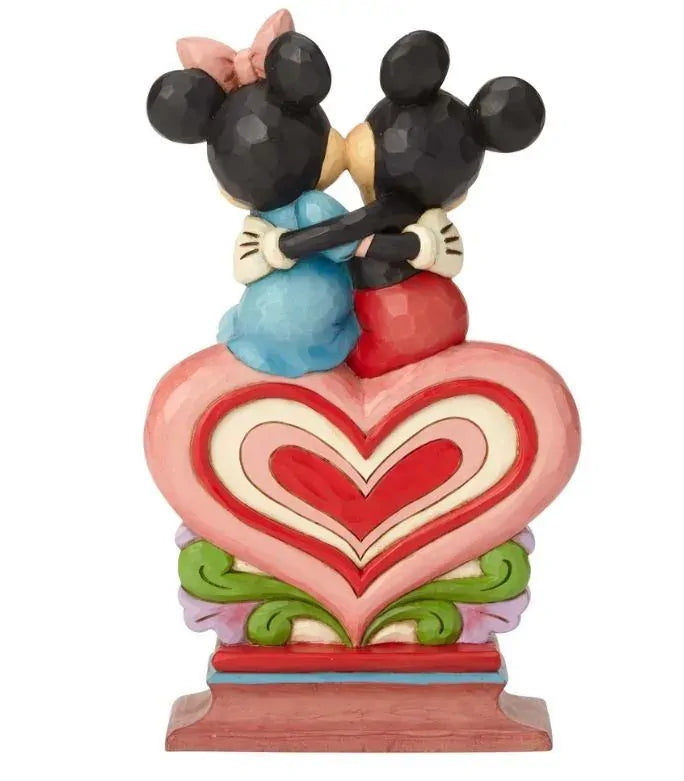 Mickey and Minnie Mouse figurine rear view, sitting together atop a layered concentric heart pedestal with colourful scrollwork base