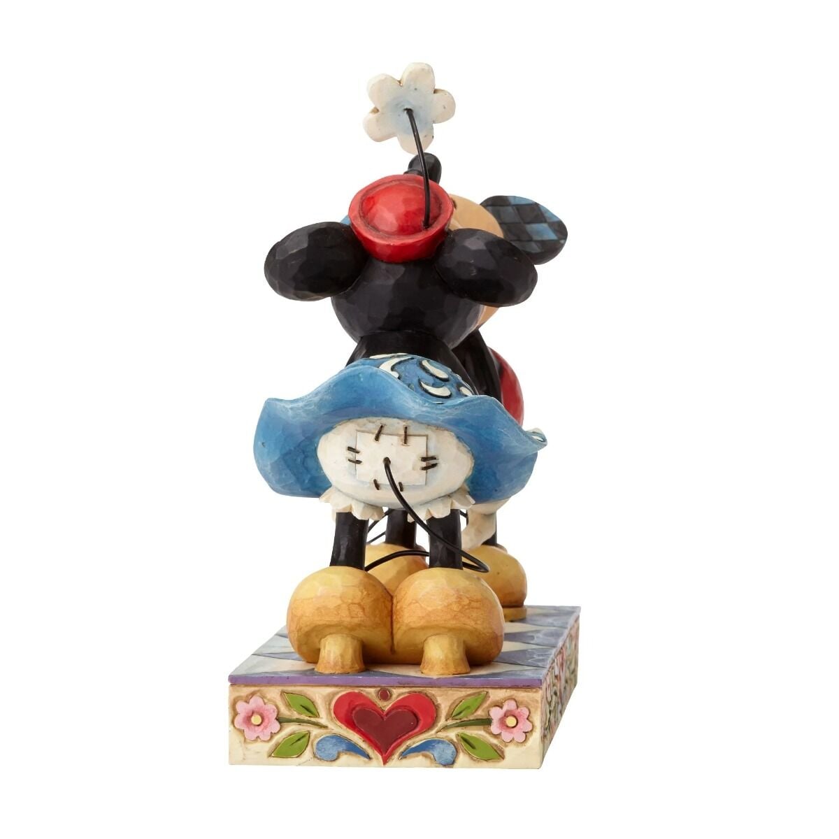 Mickey and Minnie Mouse figurine back three-quarter view, showing Minnie's blue scrollwork skirt, red hat, and floral base
