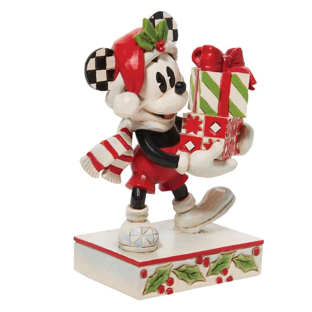 Mickey Mouse in Santa hat carrying stacked presents with striped scarf, on holly-decorated base