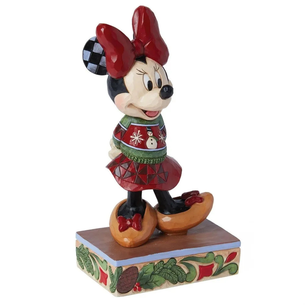 Front-facing view of a Minnie Mouse Christmas figurine in a snowman-print sweater and geometric red skirt, on a holly base. 