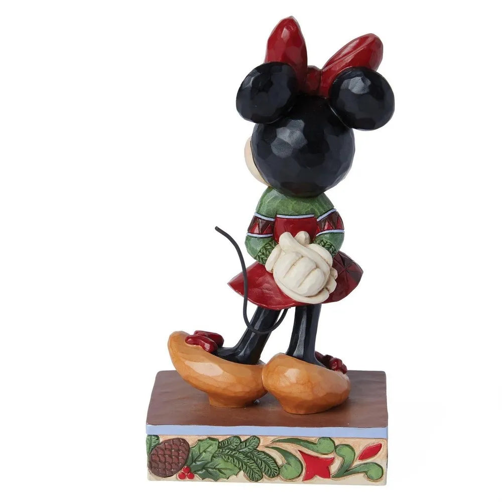 Rear view of a Minnie Mouse Christmas figurine in a red and green outfit, showing back detail and holly-decorated base.