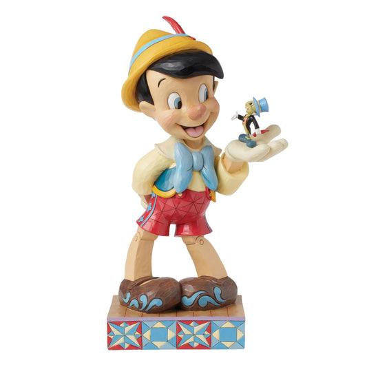Pinocchio and Jiminy Cricket figurine, Pinocchio holding Jiminy on outstretched hand, yellow hat, red shorts, star quilt base