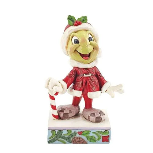 Jiminy Cricket Christmas figurine in a Santa outfit holding a candy cane, holly-trimmed hat, on a pinecone and holly base.