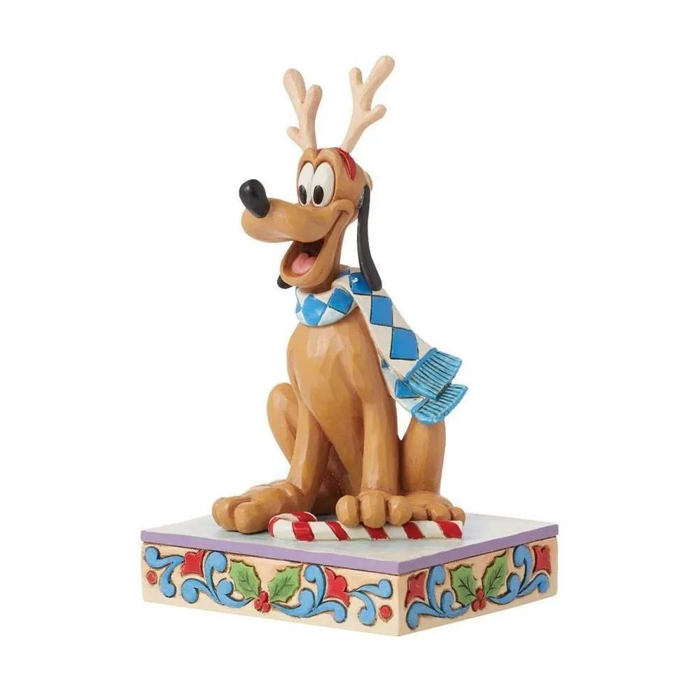 Angled front view of a Pluto Christmas figurine with reindeer antlers and blue scarf, seated over a candy cane on a holly base.