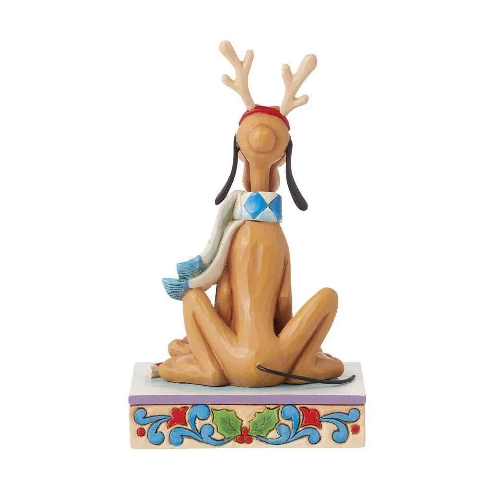 Rear view of a Pluto Christmas figurine wearing reindeer antlers and argyle scarf, seated on a holly-patterned decorative base.