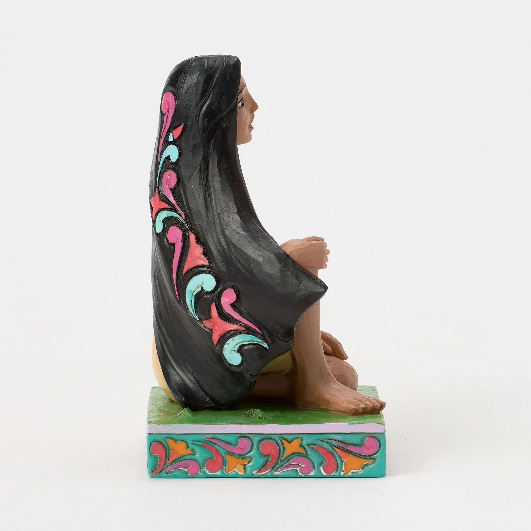 Side view of Pocahontas figurine showing full-length scrollwork detail on long black hair, teal and pink painted base