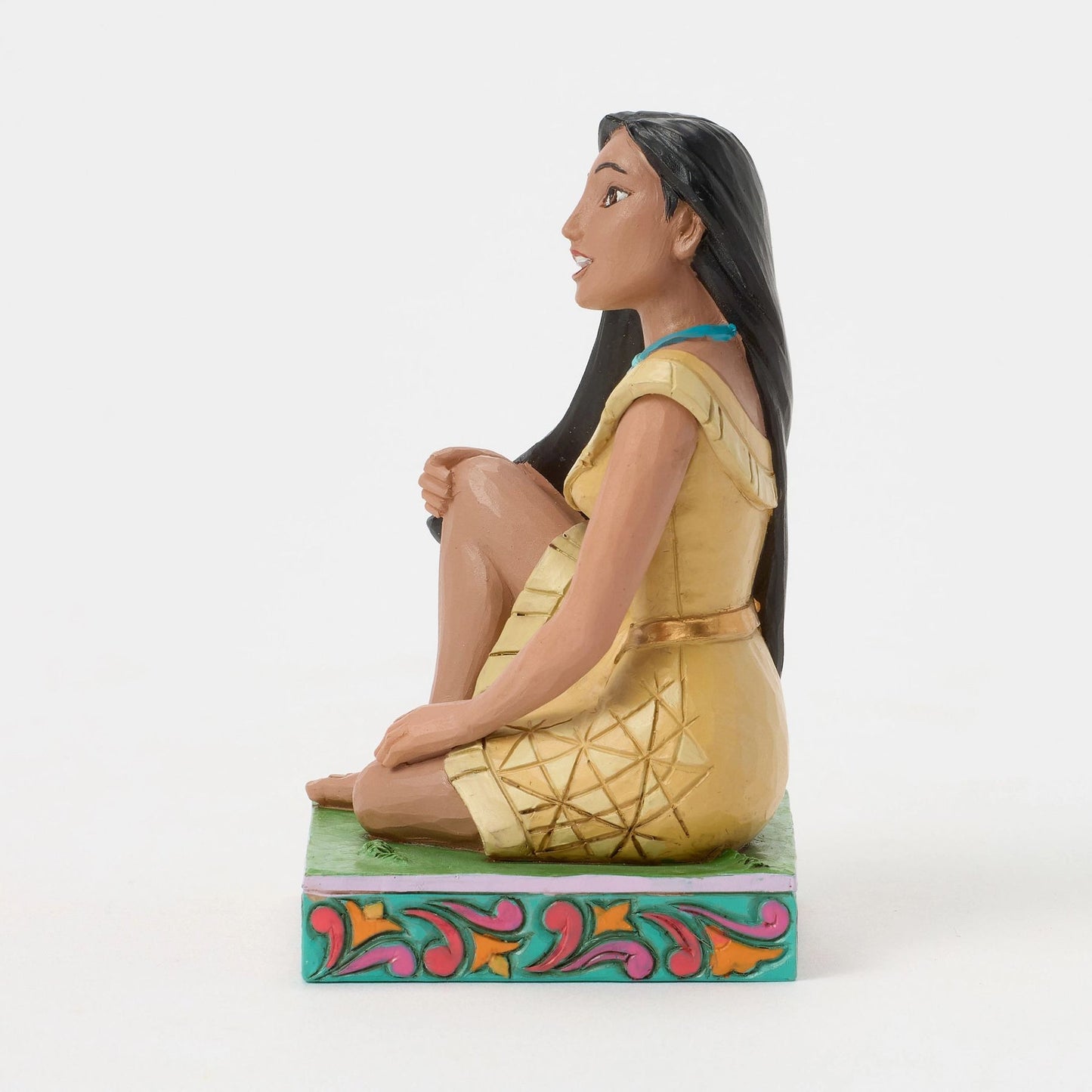 Side view of Pocahontas figurine in gold dress with geometric detail, long black hair, teal and pink painted base