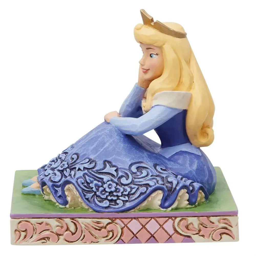 Right side view of Aurora figurine in blue gown with floral scrollwork skirt, gold crown, pink lattice base