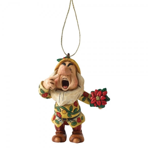 Sneezy dwarf hanging ornament with folk art detailing, mid-sneeze pose, holding a poinsettia, in a floral patterned coat