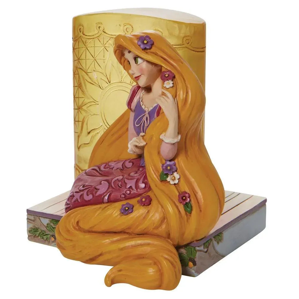 Rapunzel figurine seated beside a golden engraved tower, long flower-threaded hair pooling around her on a painted base