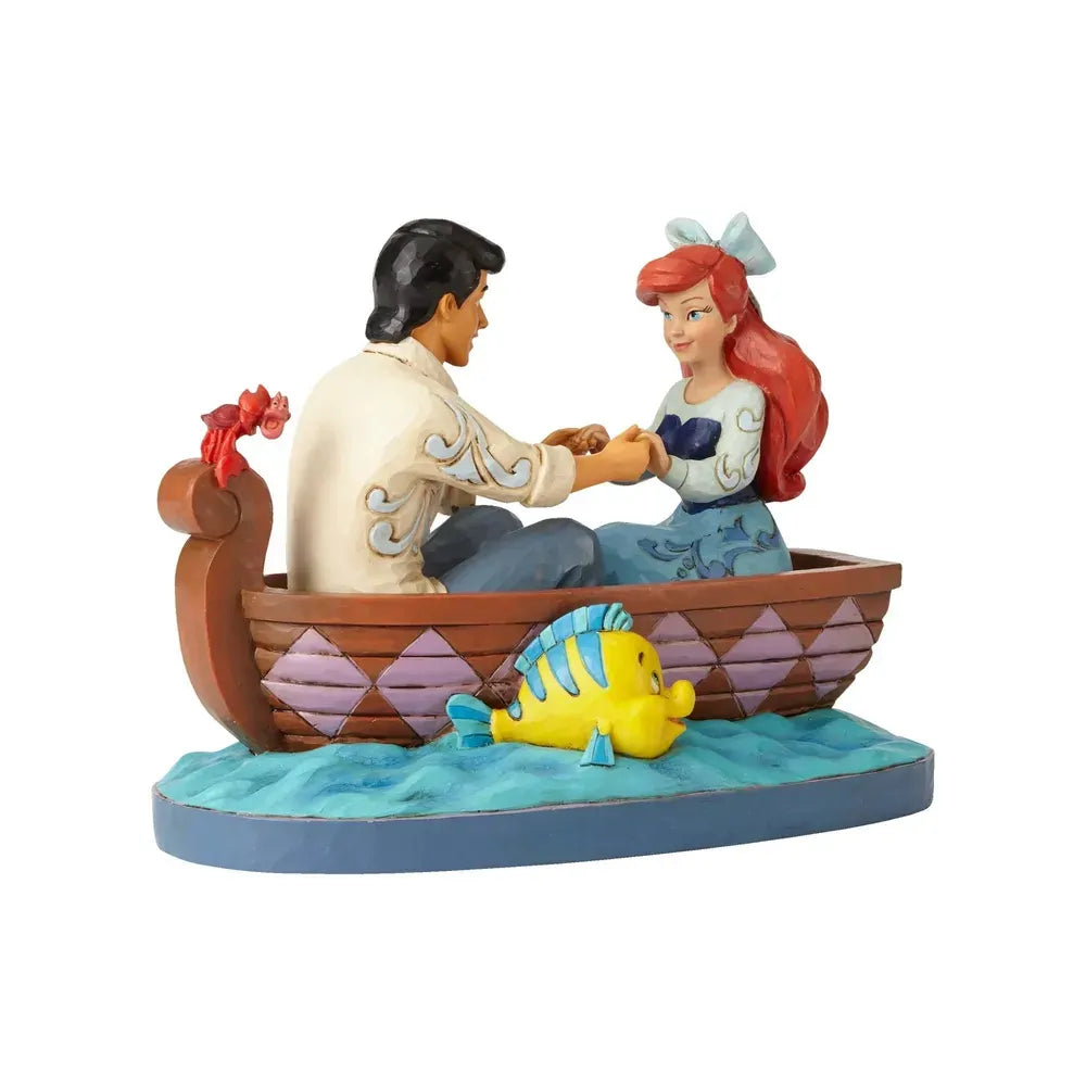 Ariel and Prince Eric holding hands in a painted rowboat figurine, Flounder at the bow, Sebastian perched on the stern